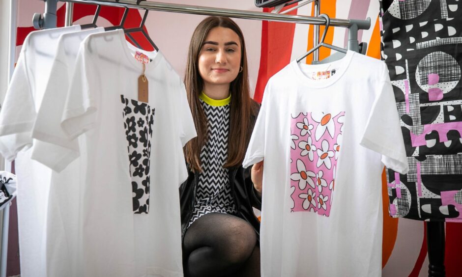 Kaitlyn Bartlett showing two of her printed Klash Fashion t-shirts