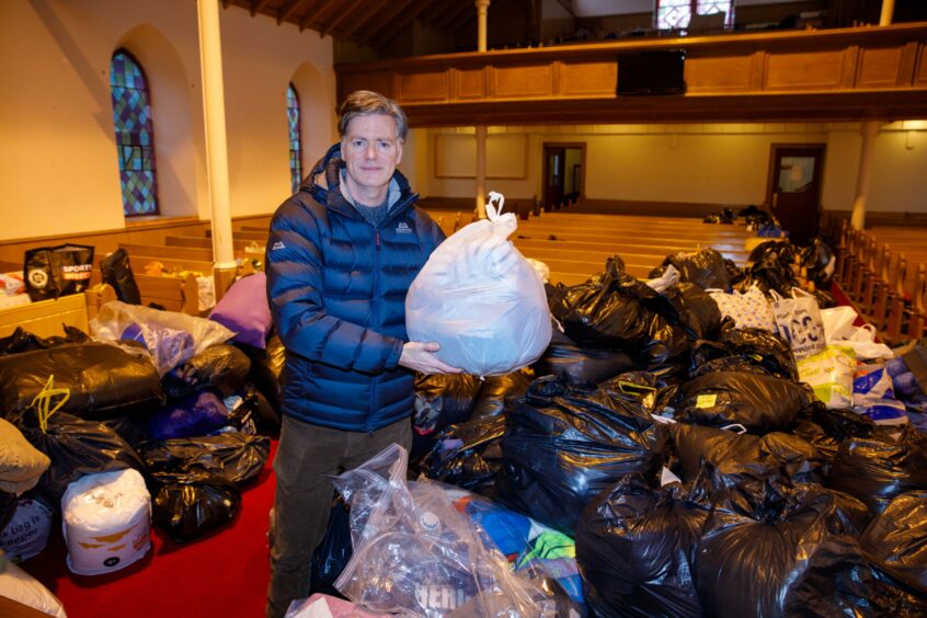 Dr McConnell with bags of aid collected at Downfield Mains Church for Ukrainians in April.