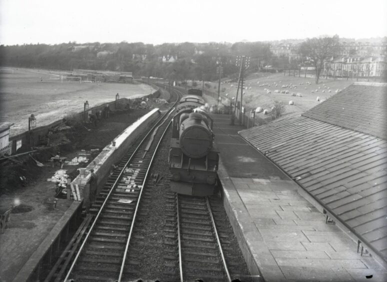 a train sits at the platform at Magdalen Green Station in March 1949