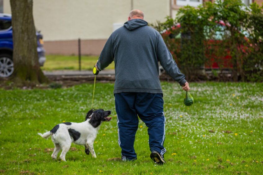 man walking dog and carrying poo bag