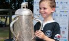 Young Strathie Shark Liam Reid got hisn hands on the Calcutta Cup when it visited Forfar in 2018. Pic: Strathmore Community Rugby Trust.