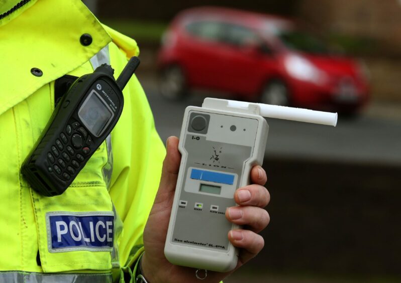 Police officer holding a breathalyser