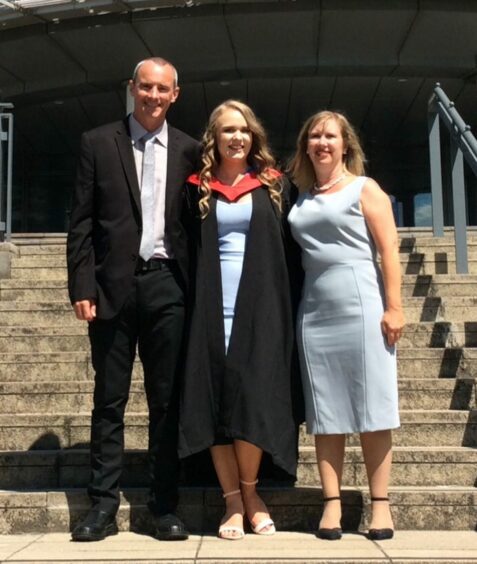 Emma with her parents Stuart and Jane, who are both deaf, at her graduation. 