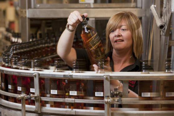 woman inspects bottle at Diageo packaging facility