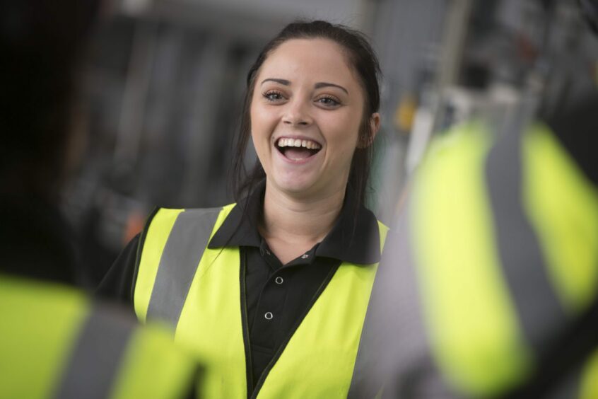 female employee smiles as she works at Diageo's packaging facility