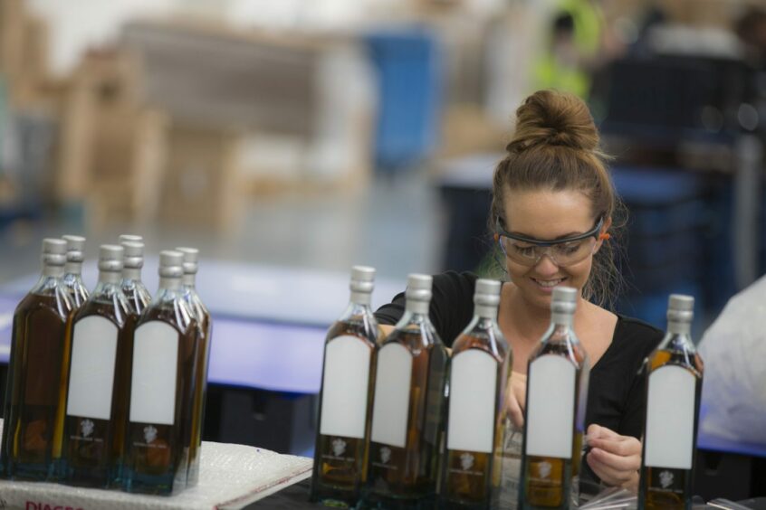 woman inspects bottles at Diageo's packaging facility