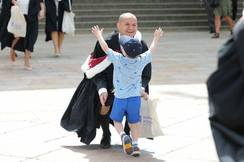 Murray Herd from Dundee who graduated in dentistry is greeted by his son Finlay, 4.