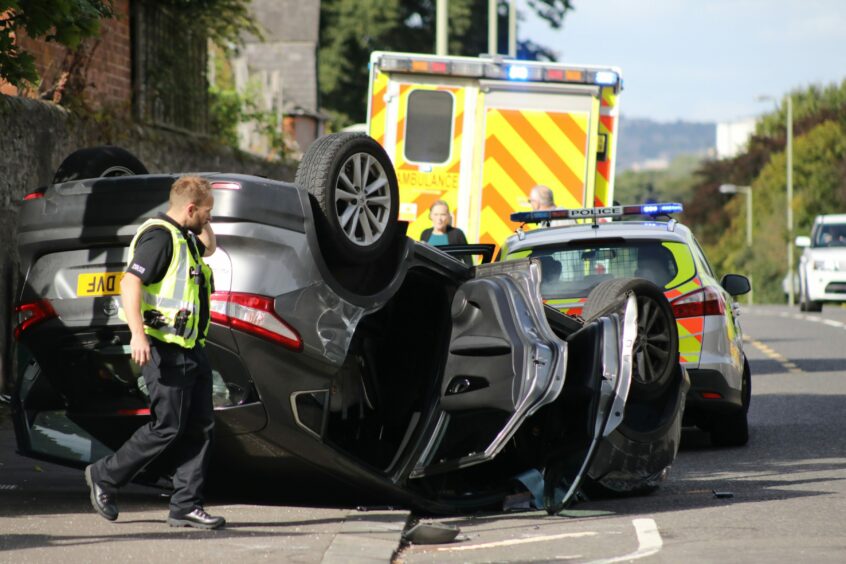 A car is flipped upside down at the Fairfield Road and Strathern Road junction, Dundee, after a crash in 2019.