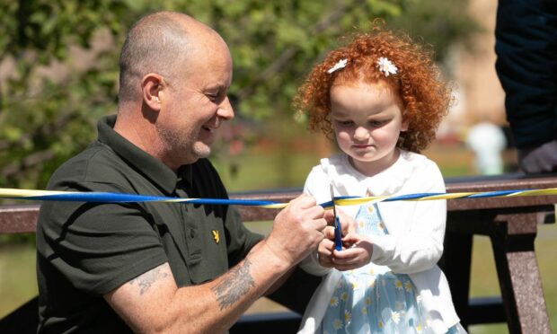 Gordon Duffy helps Zariyah Duffy cut the ribbon to open the new Douglas Community Park.