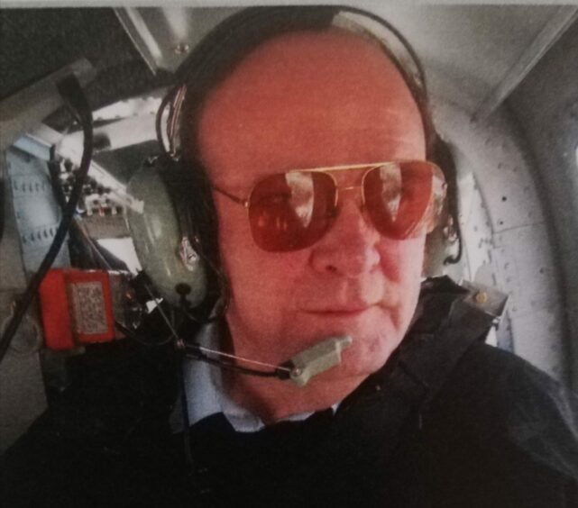 Kenny Lamond pictured in aviator sunglasses and a headset, during a helicopter ride.