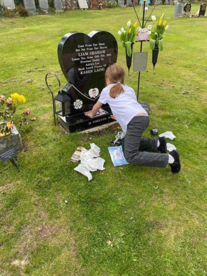 Ashlyn tending to her dad's grave.