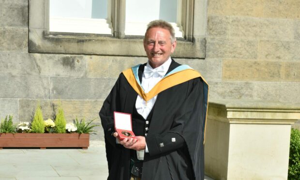 The medal was presented in recognition of his contribution to the education of young people in St Andrews.