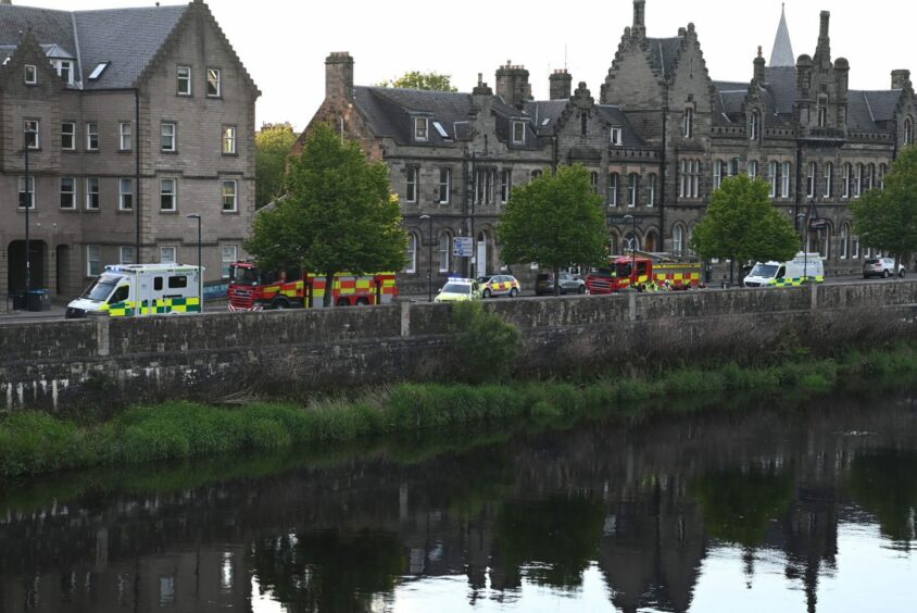 Emergency service vehicles at the scene by the river