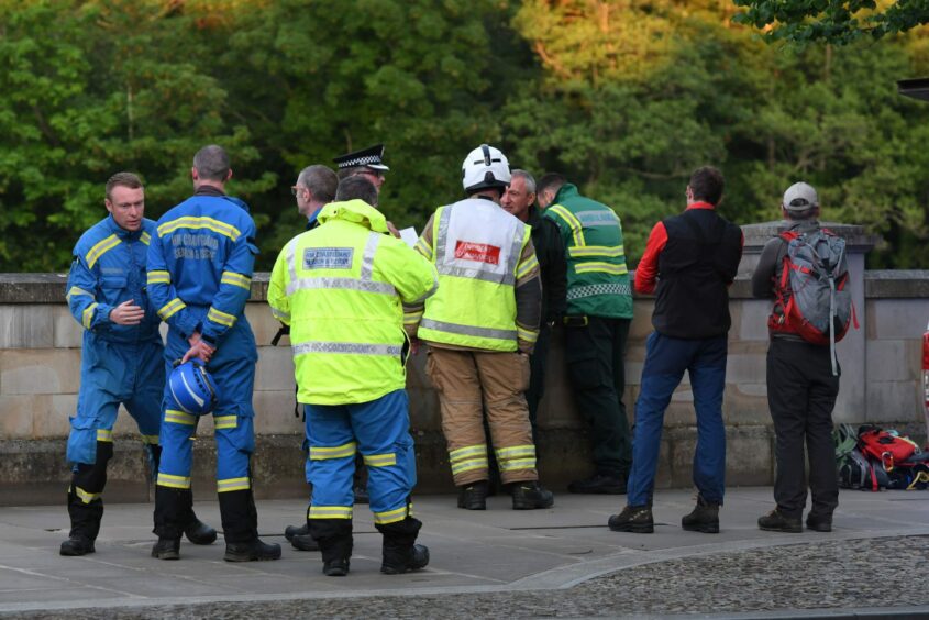 Emergency personnel gathered on the banks of the river.