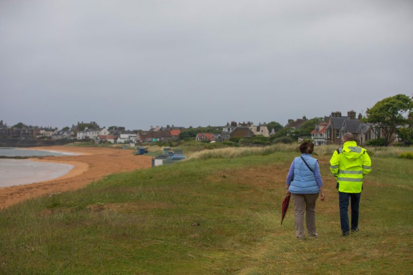 Angela and Robbie walk over an area where the marram grass has been mown down.