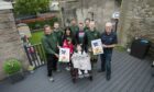 Sophie Stewart and her family along with workers from Tayside Garden Services in their newly revamped outdoor space. Image: Alan Richardson.