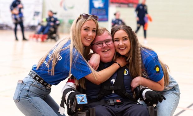 Powerchair football Logan Mitchell with proud sisters Kirstin and Isla at the Home Nations tournament in 2022.