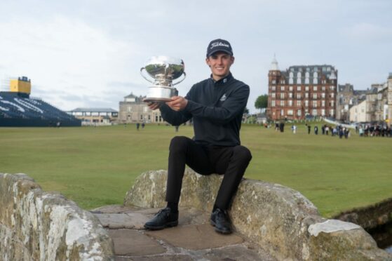 Connor McKinney with the Links Trophy on the Swilcan Bridge.