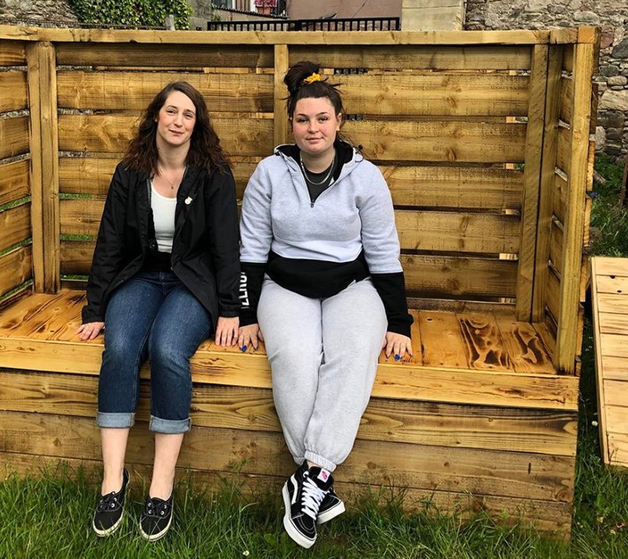 Community engagement coordinator Sam Stewart and Bethany Hart on one of the benches, which is yet to be decorated.