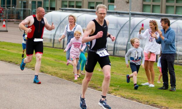 Participants of the Forfar triathlon are cheered on by bystanders.