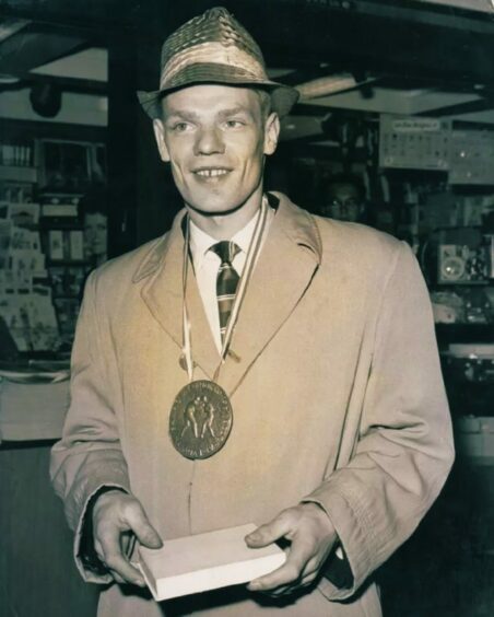 Dick McTaggart arrives home from the 1956 Melbourne Olympics with a gold medal following his victory in the lightweight division in Australia.