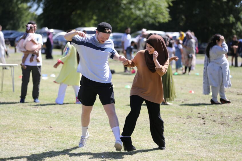 Locals take part in the three-legged race at Eid in the Park Dundee 2022