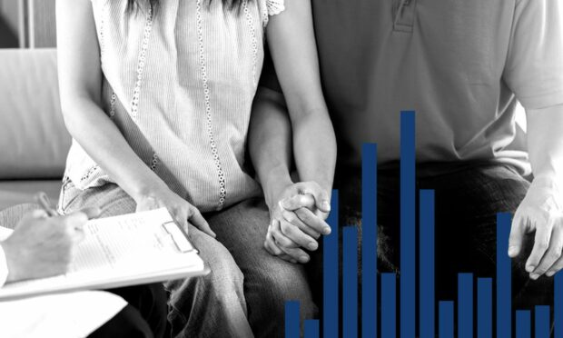 A couple sitting holding hands with bar chart in the foreground which symbolises IVF waiting times in scotland