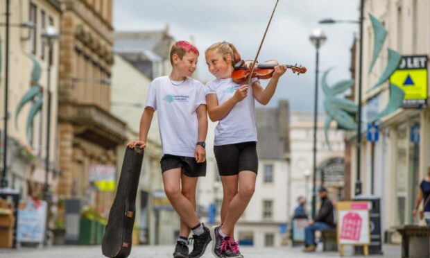 Elizabeth Maclean, 11, of the Goodlyburn Gaelic Medium In Perth performs in the city centre with her brother James, 9, at the launch of the Royal National Mòd.