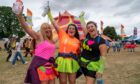 Three women in colourful 80s fashions at Rewind Scotland festival at Scone in 2022.