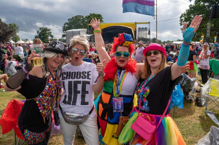 music fans in colouful 198s fashions and Choose Life t shirt at the Rewind music festival at Scone Palace in 2022.