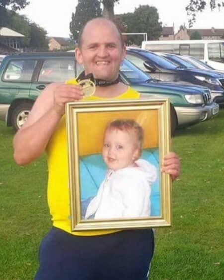 Alan with a picture of Alexis Rose after completing Leeds Half Marathon.