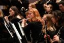 Flutist performs in a youth orchestra concert by the NYOS