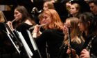 Flutist performs in a youth orchestra concert by the NYOS