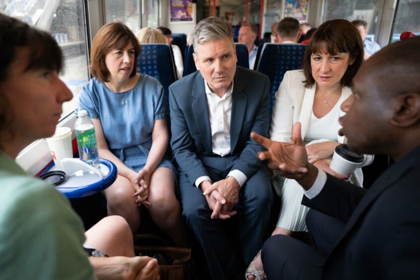 Labour leader Sir Keir Starmer, centre, travelling by train with members of his shadow cabinet. Stefan Rousseau/PA Wire.