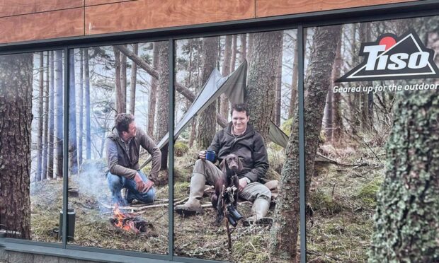 The image of the campfire in the window of Tiso Perth,