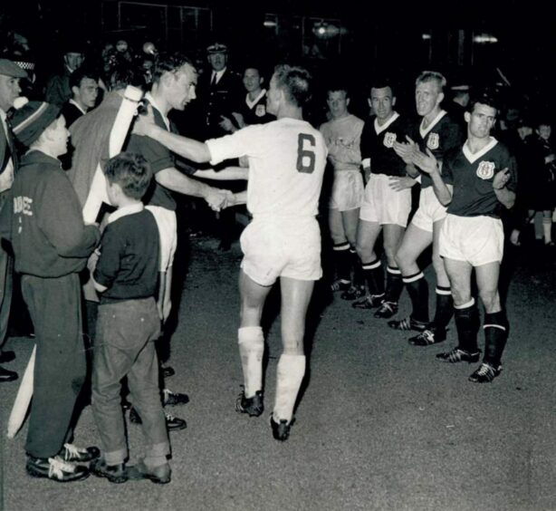 Alan Gilzean offers a hand of friendship at full time as the Dundee players clap the Cologne side off the pitch.