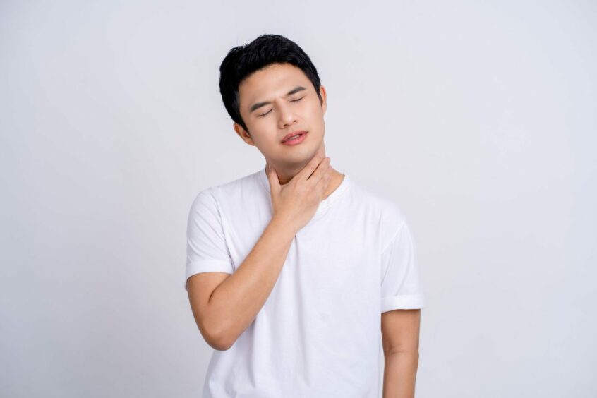 A man with a sore throat. Cold and Covid symptoms may look and feel similar.