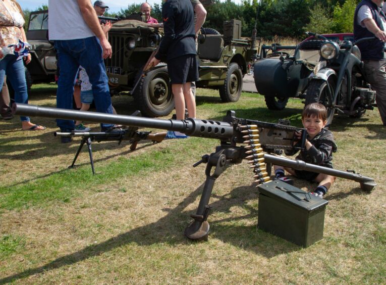 Three-year-old Jack Young with one of the military machine guns on show.