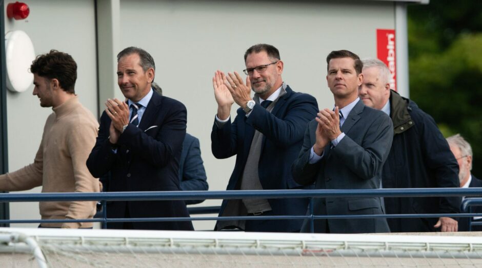Dundee owners Tim Keyes (R) and John Nelms applaud the away fans at Raith Rovers.