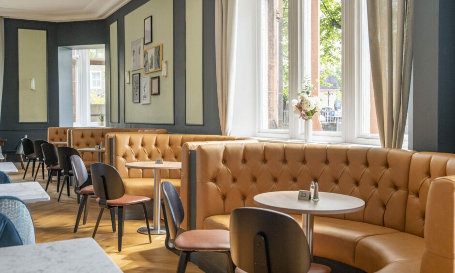 The hotel's restaurant with light brown leather curved sofas.