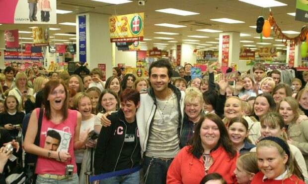 Pop star Darius surrounded by fans  in Woolworths, Dundee yesterday.