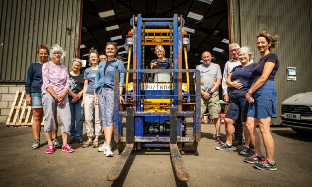 The Tayside and Strathearn Help for Ukraine group outside the warehouse - pictured with a forklift due to be sent to eastern Europe to assist with logistics.