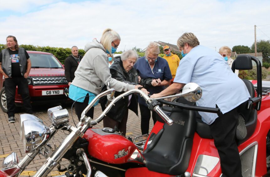 Kit being helped on to the trike.