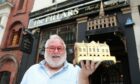 The Pillars bar manager John Justice with the brass model which was stolen last week.