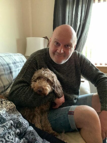 John with his daughter Hayley's dog Milo.
