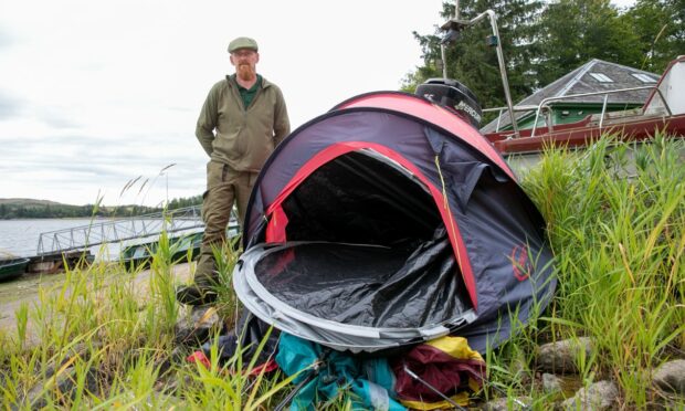 Gavin Ferguson, water bailiff, with a discarded tent at Lintrathen Loch.