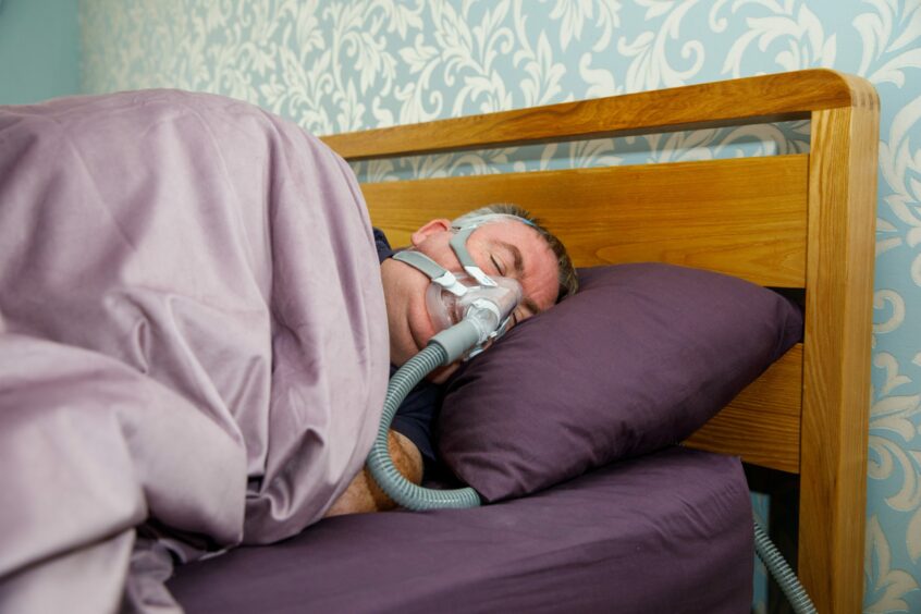 Steven asleep in bed with a mask on