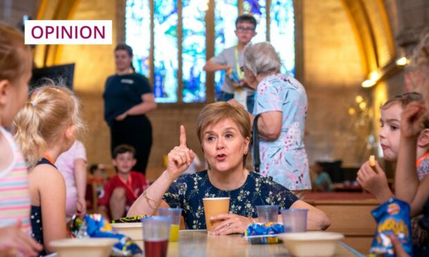 First Minister Nicola Sturgeon with local children during a visit to Lowson Memorial Church Free Breakfast Club in Forfar. Photo: Jane Barlow/PA Wire.