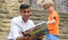 Rishi Sunak (left) looks at a book with Teddy Openshaw, four, from Whitewell, following an event in Ribble Valley, held as part of his campaign to be leader of the Conservative Party and the next prime minister. Picture via PA.