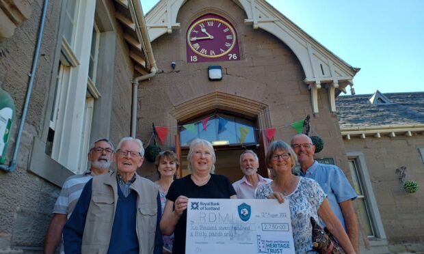 Left to right: Doug Sutherland, Noel McKinnie, Karen Donaldson, Dorothy Guthrie, Lewis Simpson, Maggie Wilkins and Kevin Gates in front of the clock at the Robert Douglas Memorial Institute in Scone.